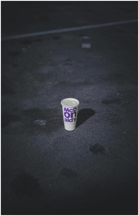 A solitary McDonald's cup sits on a deserted, dark
