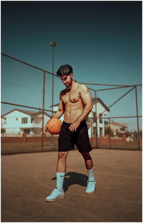 Shirtless athletic man holding a basketball on an