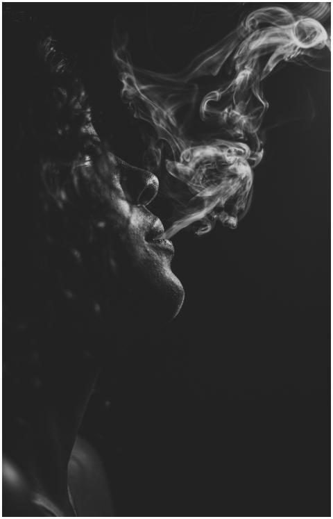 Moody black and white portrait of a woman exhaling