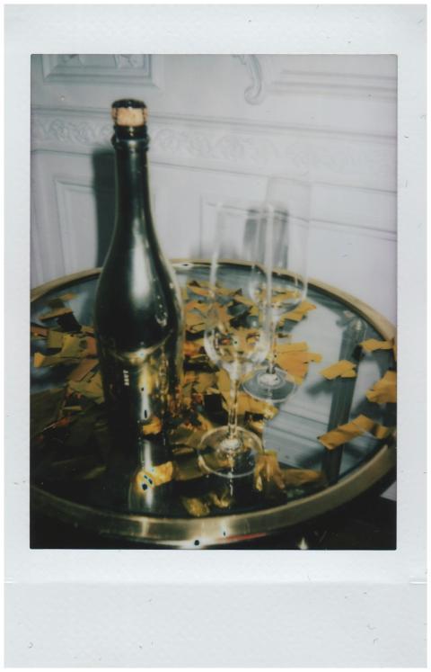 Champagne bottle with glasses and gold confetti on