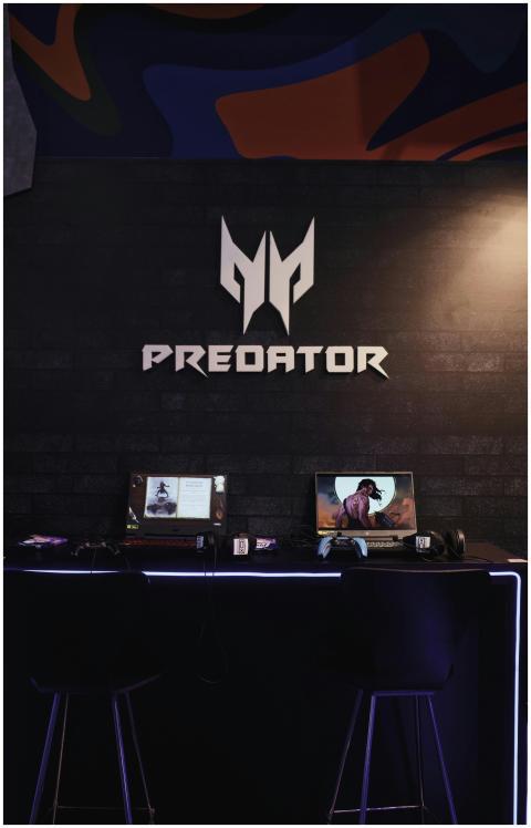 Gaming area featuring dual Predator laptops on a d