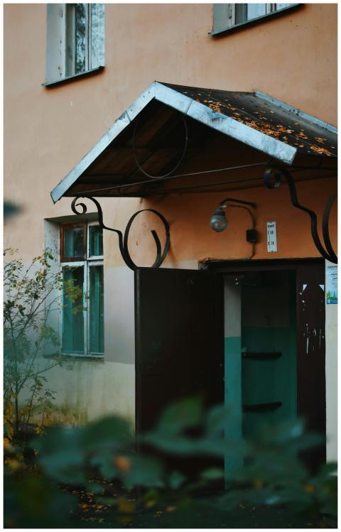 An old building entrance surrounded by autumn leav