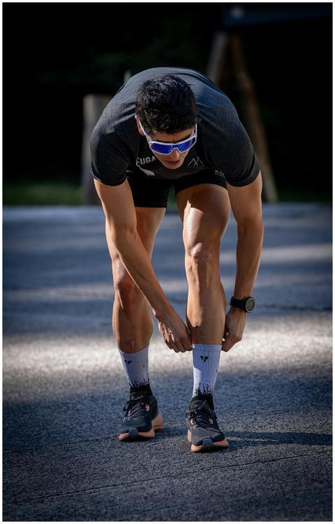 Male athlete adjusting socks before outdoor run on