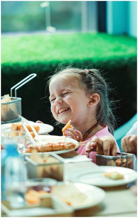 Happy girl enjoying a meal indoors, captured in vi