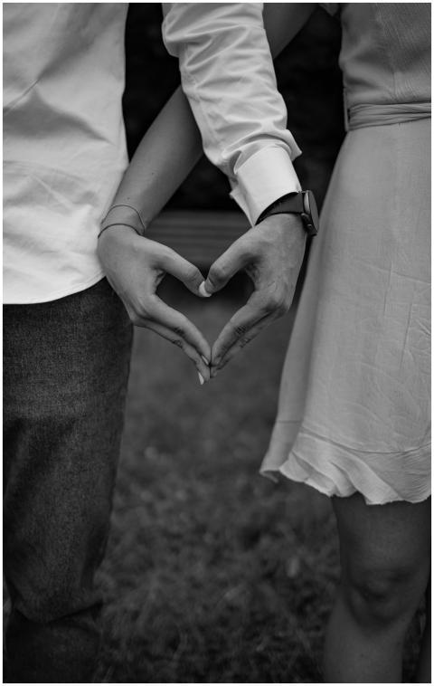 Black and white photo of couple forming a heart wi