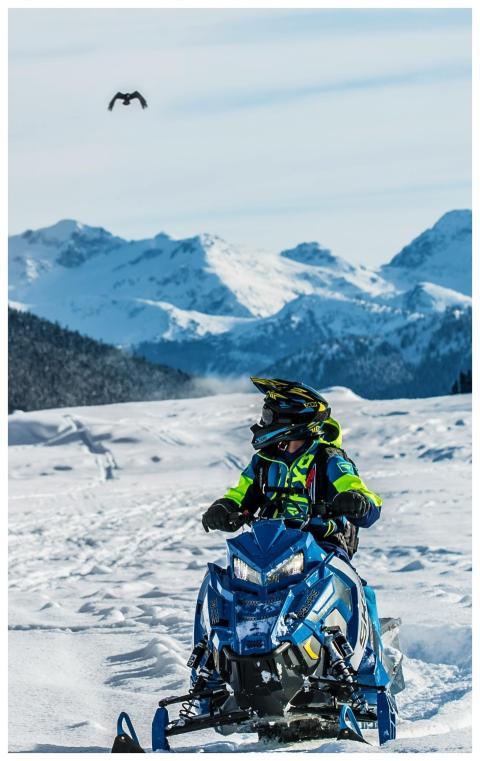 A person enjoying a snowmobile adventure in a stun