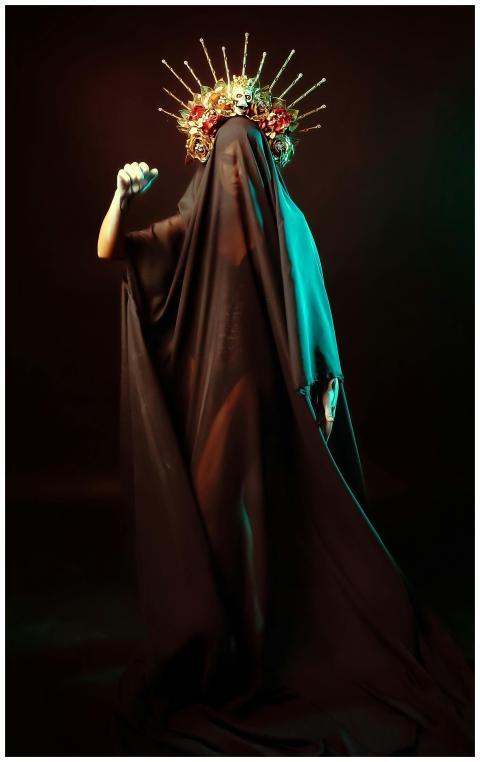 Mysterious figure shrouded in black garment and fl