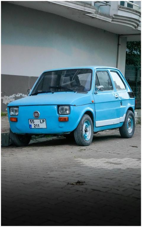A classic blue Fiat car parked on a street in Sams