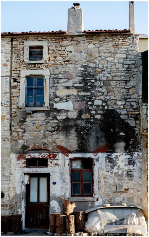 A weathered, rustic stone house facade showcasing