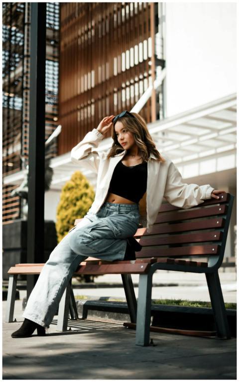 Stylish woman sitting on a bench outdoors in urban