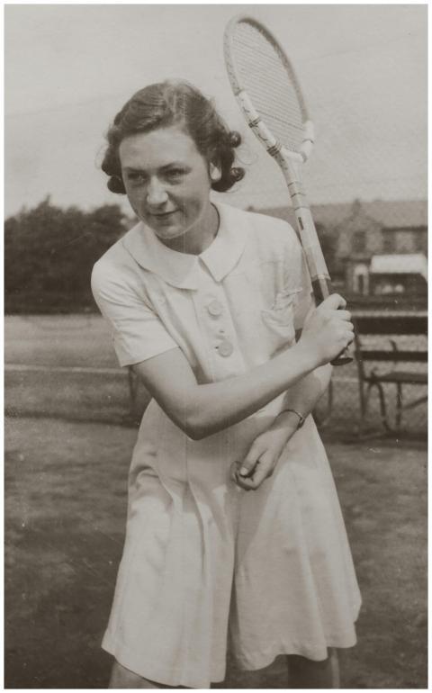 Historic black and white photo of a young woman pl