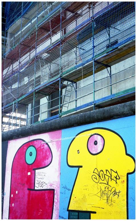 Vibrant graffiti on the Berlin Wall against a back