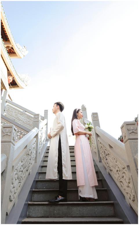 Couple in traditional clothing stand on temple sta