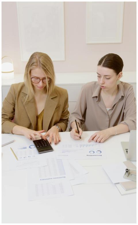 Two women working on financial documents and calcu