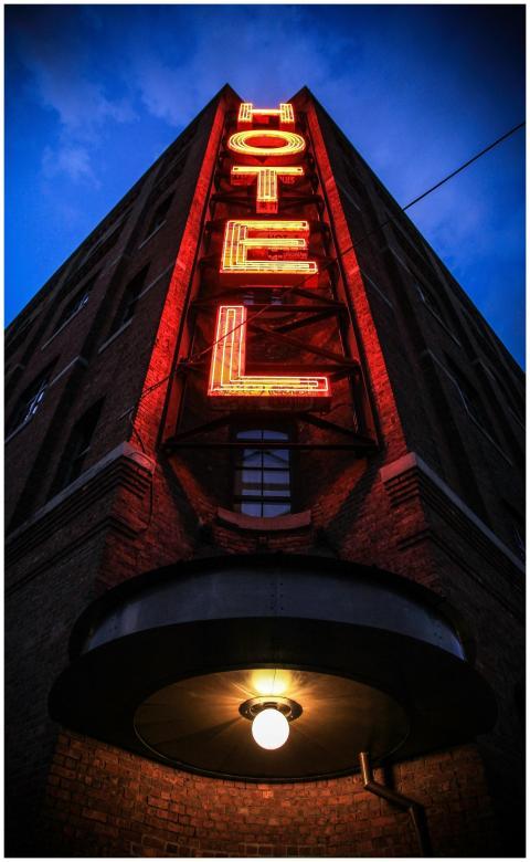 Eye-catching low angle shot of a neon hotel sign i