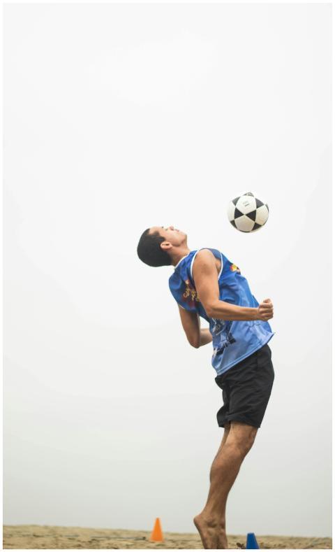 A young man dynamically performs a soccer trick ou