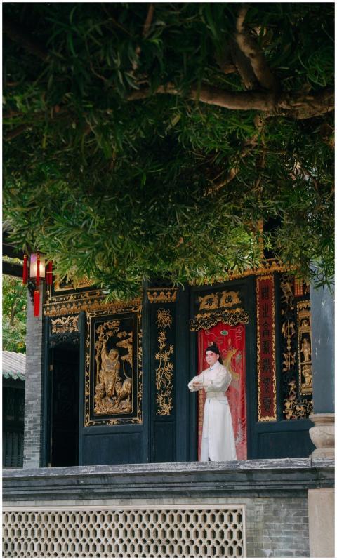 Woman in traditional attire poses in front of orna