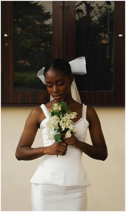Bride in white dress holding bouquet in an outdoor
