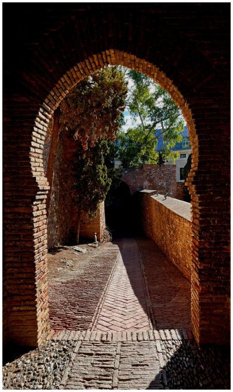 A beautiful historic brick archway leading to a su