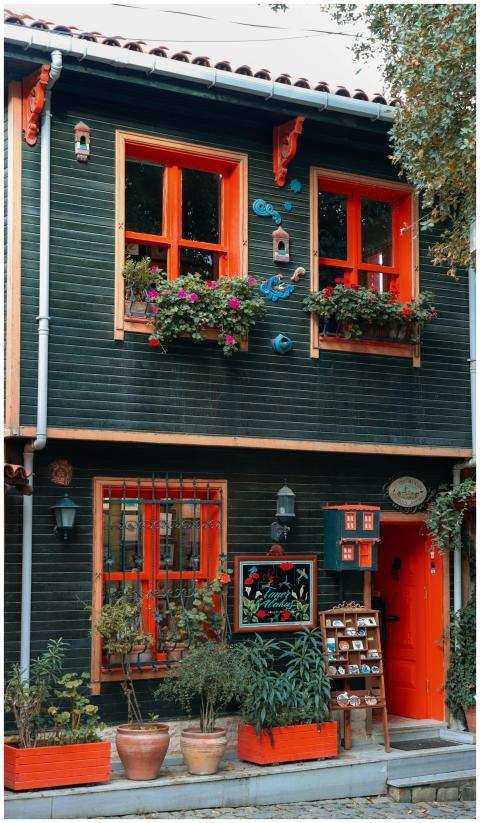 A vibrant green house with orange accents and lush