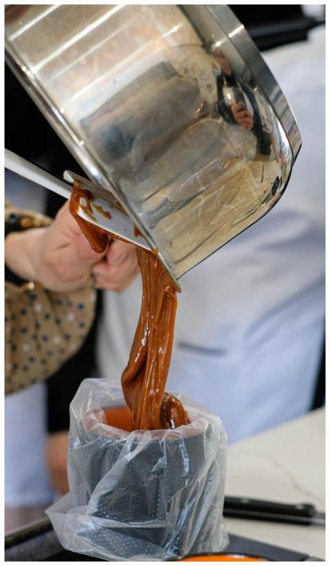 A chef pours freshly made caramel into a mold duri