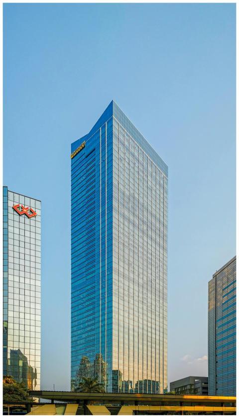 Tall skyscraper reflecting blue sky in Jakarta, In