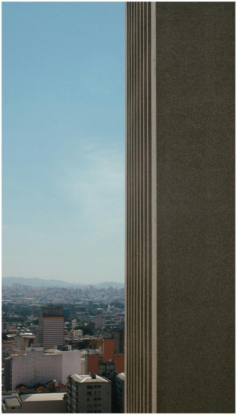 High-rise building against city skyline under clea