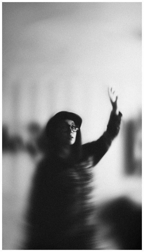 Blurred monochrome portrait of a woman with raised