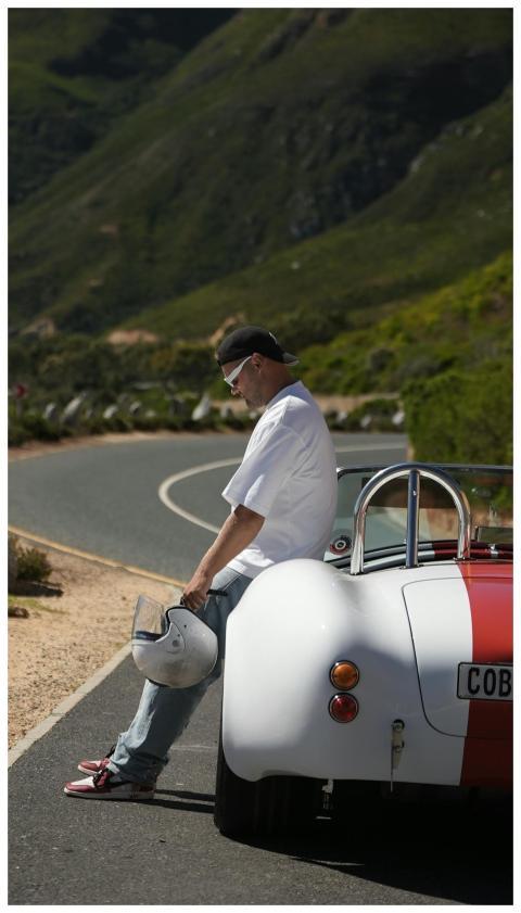 Man sitting on a classic red and white Cobra sport