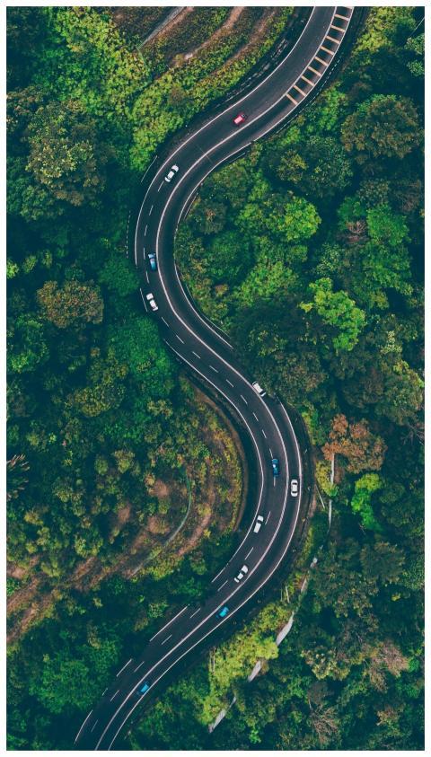 A sweeping aerial view of an S-shaped road winding