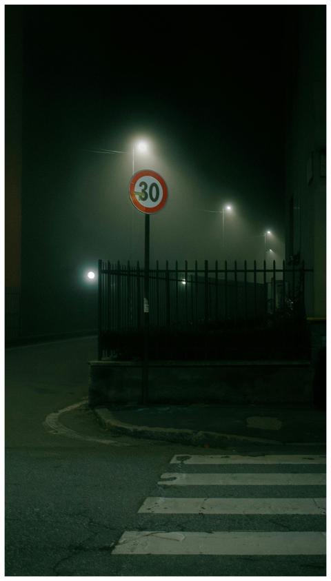 Eerie fog envelops an urban street with glowing st