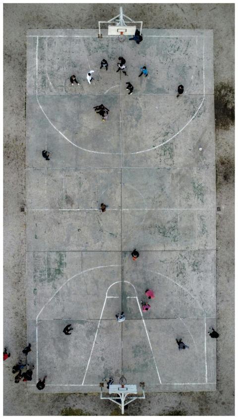 Top-down drone view of a basketball game on an out