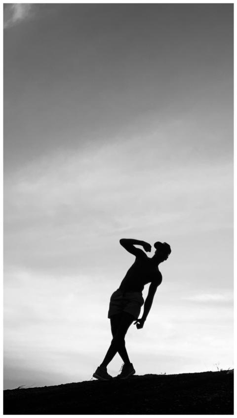 Black and white silhouette of a person striking a