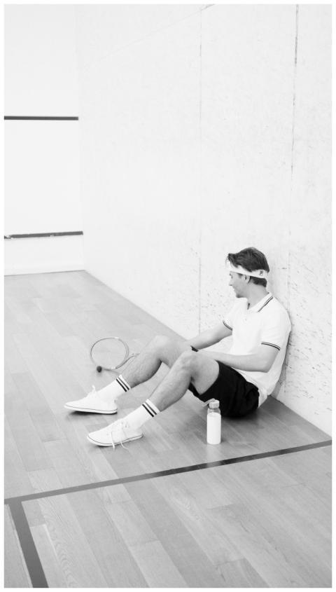 Black and white photo of a man in activewear resti