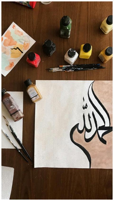 Overhead view of vivid paints and artistic Arabic