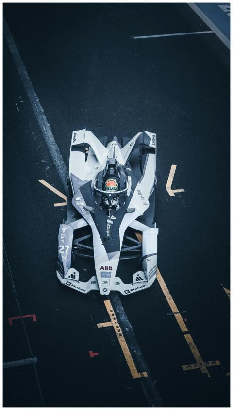 Top view of a dynamic Formula E car racing on a ci