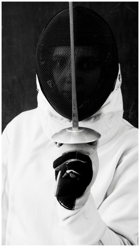 A striking black and white portrait of a fencer in