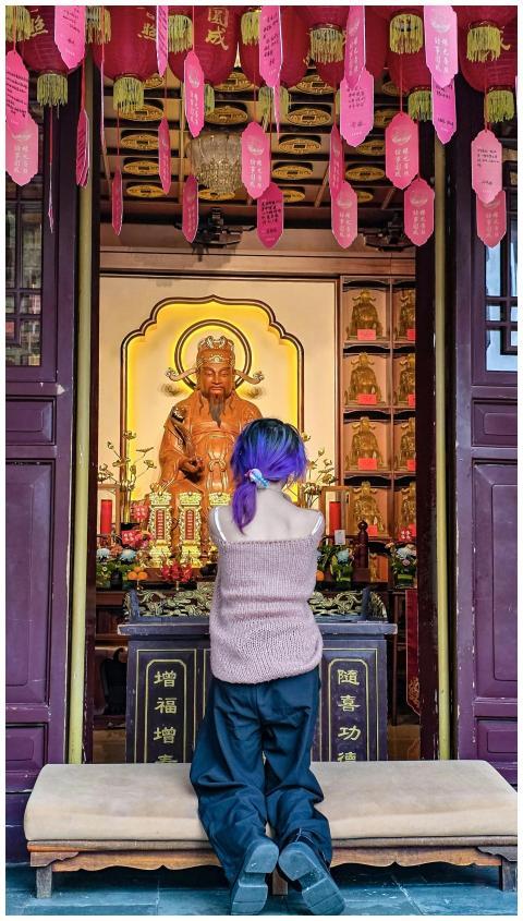 A youth prays at a traditional Chinese altar in Xi