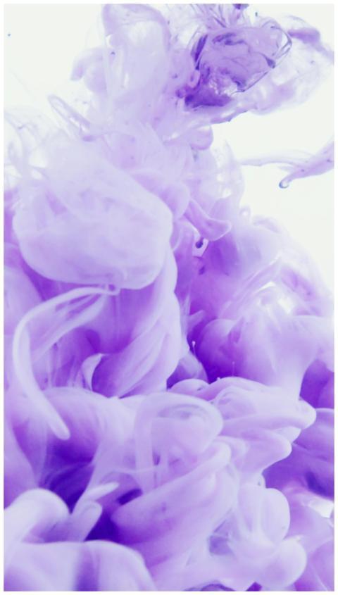 Abstract violet ink swirling in water creates a dr