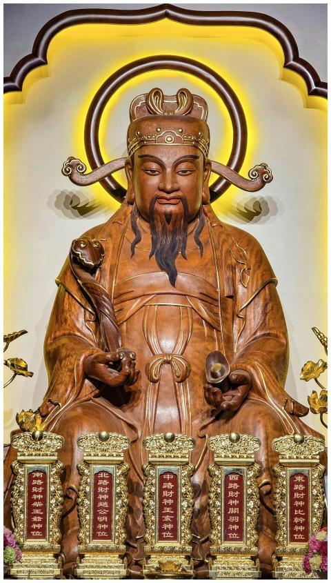 Intricate wooden statue of Chinese deity with gold