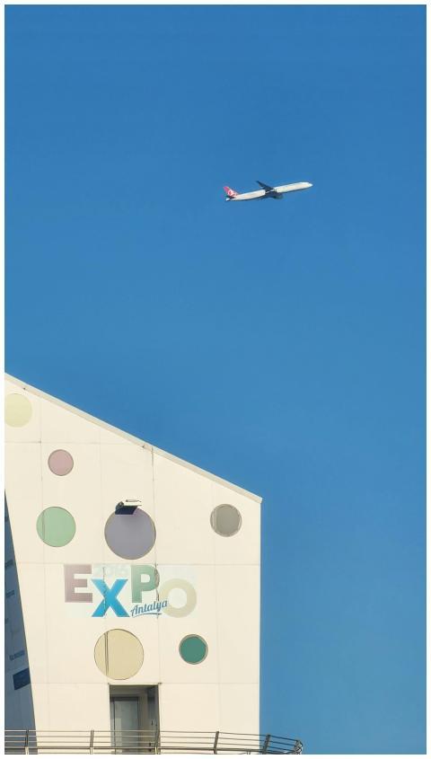 A modern airplane soars above the Expo Antalya bui