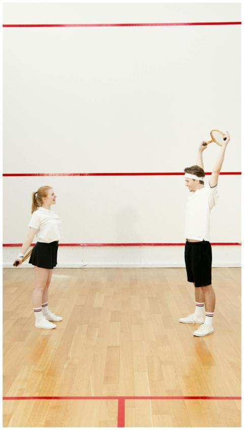 A man and woman in sportswear exercise with squash