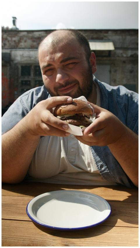 A man savoring a delicious hamburger at an outdoor