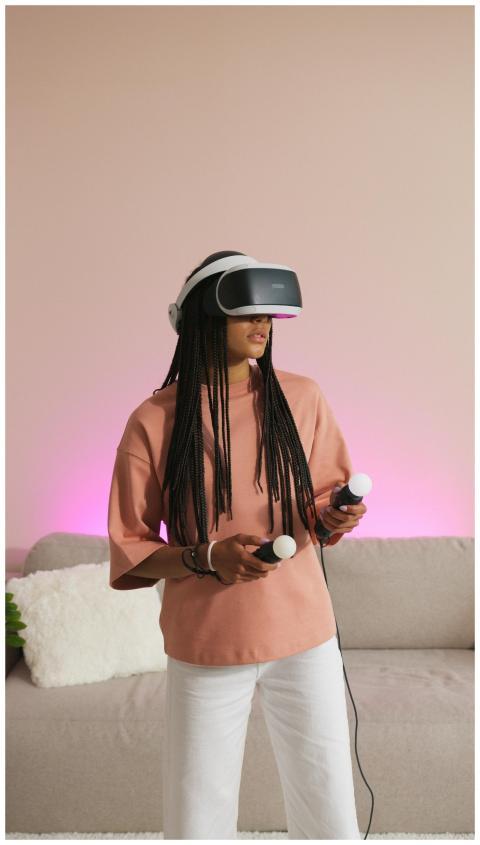 Woman with braided hair enjoying VR gaming indoors