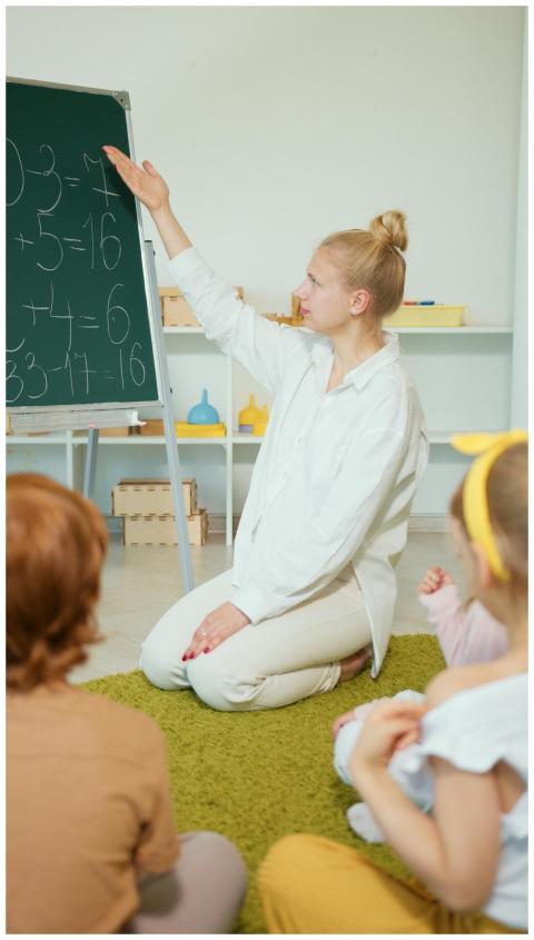 Teacher instructing children with math problems on