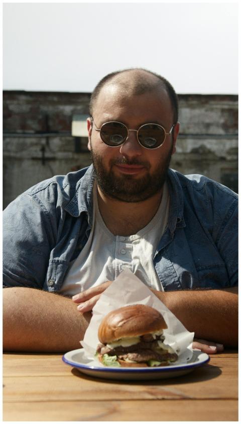 A man wearing sunglasses enjoying a delicious burg