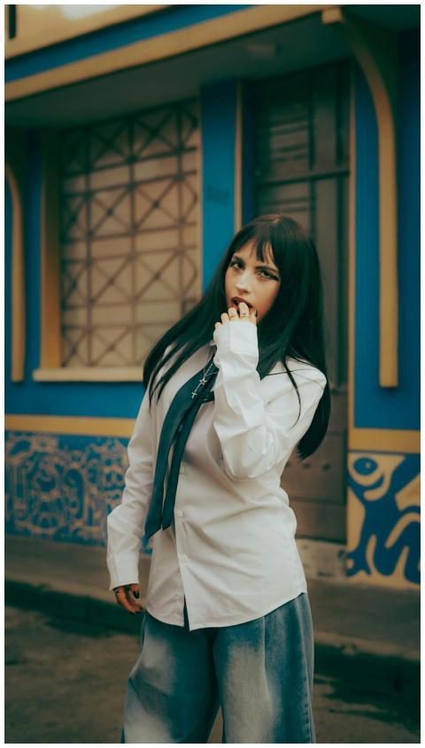 Young woman in casual wear posing in front of colo