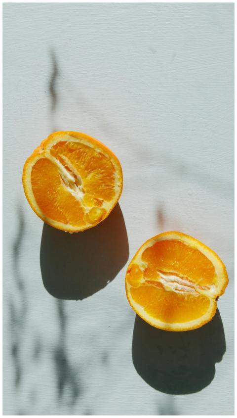 Sunlit sliced orange casting shadows on a minimali