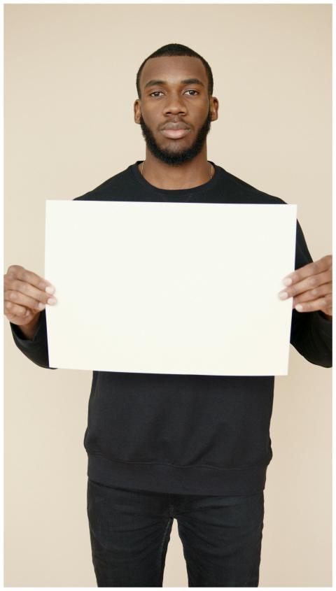 Young adult man presents a blank sign, ideal for p