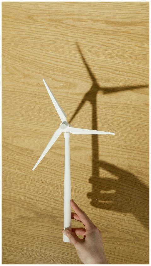 Close-up of a hand holding a small wind turbine mo